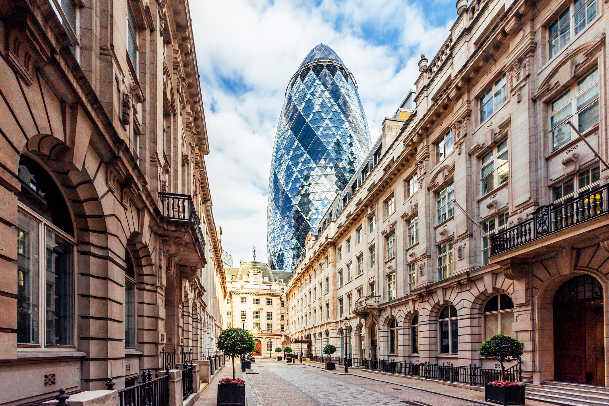 Street in London with old historic houses and 'Gherkin' skyscraper, England, UK